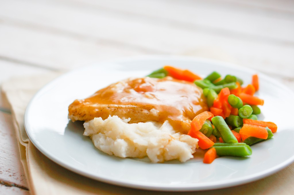 Oven baked chicken in gravy with mashed potatoes and vegetables
